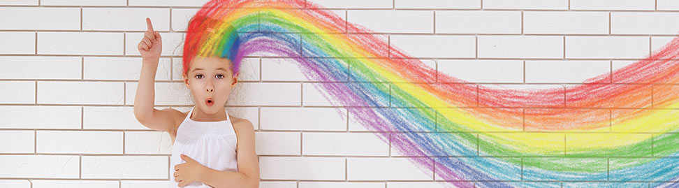 little girl in front of a wall, hair turns into a drawn rainbow