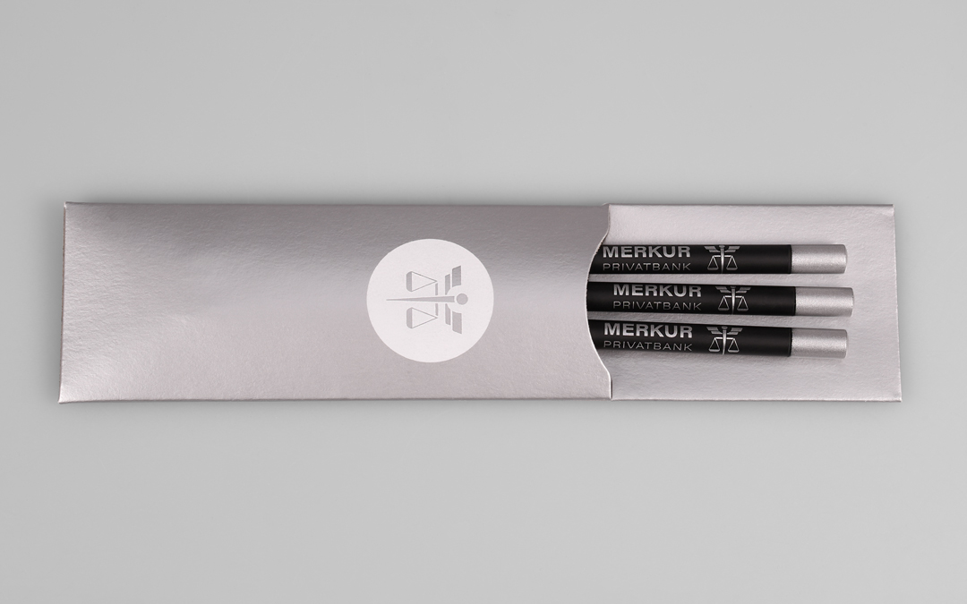 pack case with white imprint and three black colored pencils with silver lacquered cap and silver printing motiv