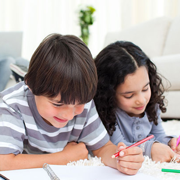 colored pencils for children, with boy and girl coloring pitures on the floor