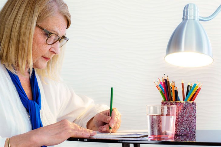 coloring for adults, with colored pencils and book on a table