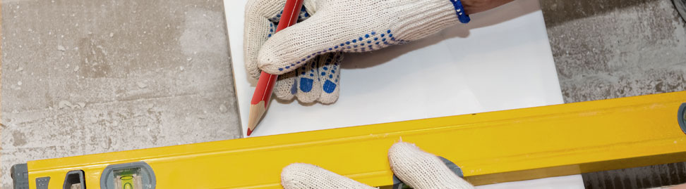 man marking with all-writing pencil on white tile